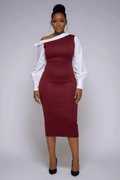 Woman wearing a burgundy and white dress against a plain background