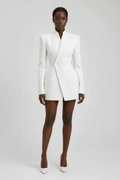 Woman wearing a white blazer and skirt set on a plain background