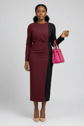 Woman wearing a two-tone dress with a pink handbag on a white background