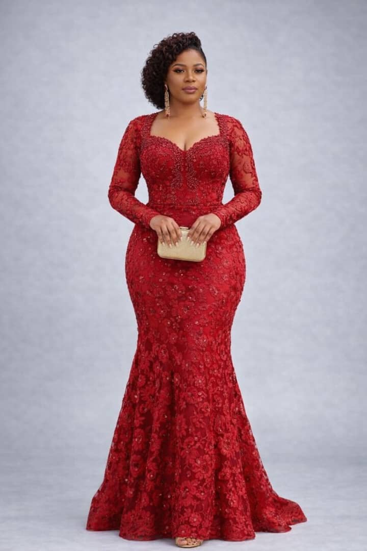 Woman wearing a red lace dress against a gray background